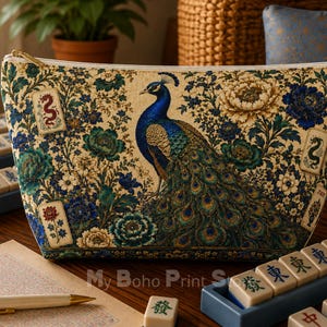 May include: A zipped pouch featuring a detailed print of a peacock surrounded by blue and cream floral patterns and small rectangular tiles with dragon and flower illustrations. The fabric has a gold-toned zip closure along the top edge.