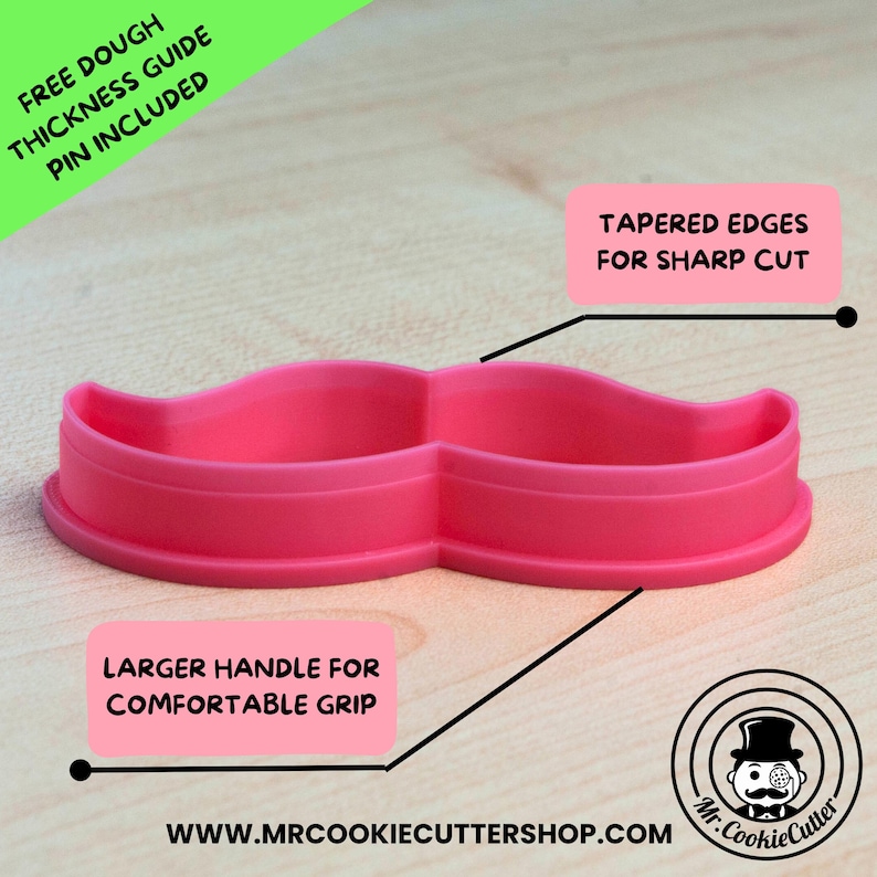 May include: Pink plastic moustache cookie cutter with a larger handle for a comfortable grip. The cutter has tapered edges for a sharp cut. The text "FREE DOUGH THICKNESS GUIDE PIN INCLUDED" is in the top left corner of the image. The text "TAPERED EDGES FOR SHARP CUT" is in the top right corner of the image. The text "LARGER HANDLE FOR COMFORTABLE GRIP" is in the bottom left corner of the image. The text "WWW.MRCOOKIECUTTERSHOP.COM" is in the bottom centre of the image. The text "Mr. CookieCutter" is in the bottom right corner of the image.