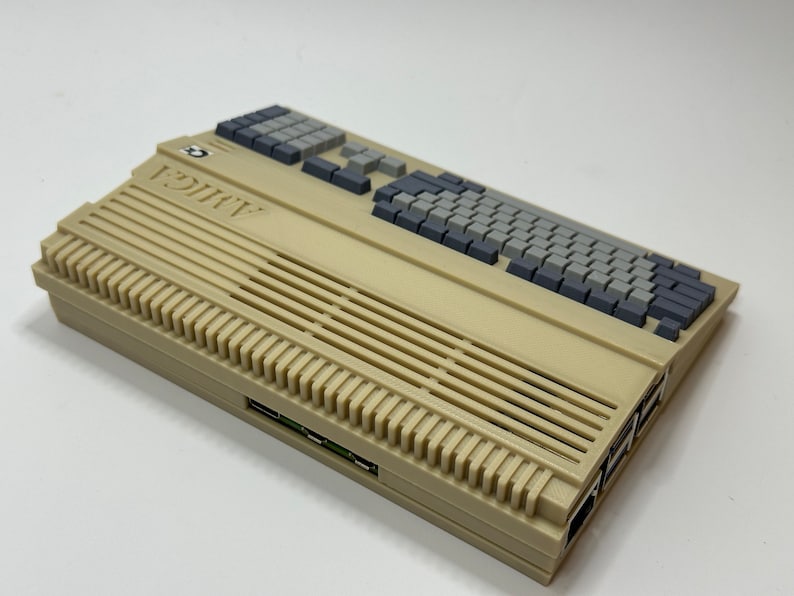 以下が含まれることがあります： グレーのキーボードと側面に複数のスロットが付いたベージュ色のアタリ 800 XL コンピューターです。