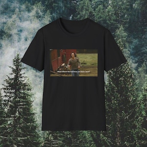 Pode incluir: Uma t-shirt preta de manga curta com uma impressão gráfica retangular no peito. A impressão mostra uma cena de uma pessoa a correr ao ar livre com o texto "Bella! Where the hell have you been, loca?" em letras brancas na parte inferior.