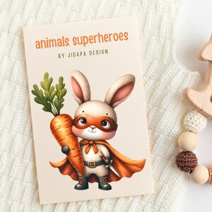 Op de afbeelding: Een schattig cartoonkonijn dat is verkleed als superheld en een wortel vasthoudt. Het konijn draagt een rode cape, een bruine riem met een zilveren zwaard en een oranje masker. De tekst "animals superheroes" en "by JidAPA design" staat op de kaart gedrukt.