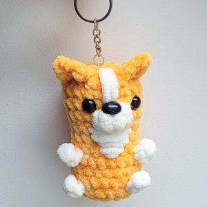 This lovely corgi keychain is a work of art, flaunting its soft, orange plush fur, delicate white spots, and captivating black button eyes.