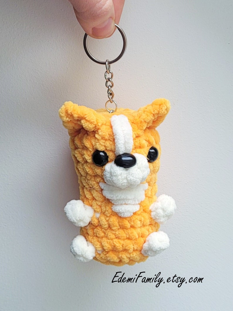 This lovely corgi keychain is a work of art, flaunting its soft, orange plush fur, delicate white spots, and captivating black button eyes.