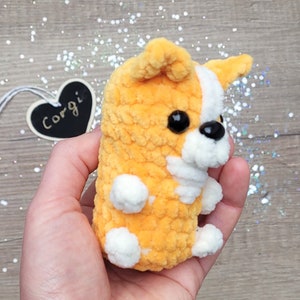 This handcrafted corgi keychain boasts a cute design with soft orange fur, white markings, and charming black bead eyes.