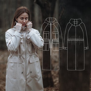 Puede incluir: Un abrigo largo beige con capucha, cintura con cordón y bolsillos grandes. El abrigo se muestra en una modelo en un entorno de bosque. A la derecha de la modelo se muestra un dibujo de línea del abrigo.