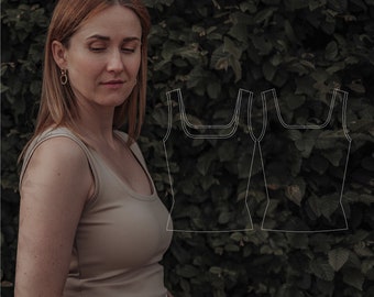 May include: A woman wearing a light brown tank top with a brown belt and white pants. The tank top has a scoop neck and a relaxed fit. The image includes a line drawing of a tank top.