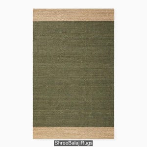 Op de afbeelding: Een rechthoekig tapijt in groen en beige met een geweven textuur. Het tapijt heeft een beige rand en een groen midden.