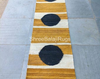 May include: A rectangular runner rug with a mustard yellow and white striped pattern, featuring three large, dark gray circles. The rug has the text "ShreeBalajiRugs" in white.