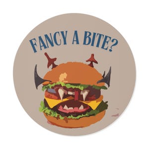 May include: A circular graphic depicting a cartoon burger with devilish features, including horns and fangs. The burger is composed of lettuce, cheese, and a sesame seed bun. The text "FANCY A BITE?" is arched above.