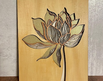 Puede incluir: Una pieza de arte de pared de madera con un diseño en capas, 3D de una flor con acentos verdes y dorados.