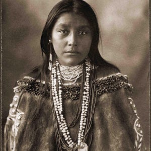May include: A black and white portrait of a Native American woman wearing a beaded necklace and traditional clothing. The text "Mattie Tom Apache" is written below the image.