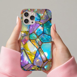 以下が含まれることがあります： ステンドグラスを思わせる、カラフルな幾何学模様の携帯電話ケース。紫、青、黄、緑の色合いのイリデセントな形のモザイクが特徴です。携帯電話ケースには、3つのレンズを備えたカメラモジュールが付いています。