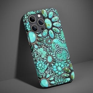 Puede incluir: Funda de teléfono turquesa con un patrón decorativo de piedras turquesas de varios tamaños y detalles metálicos plateados. La funda tiene un acabado brillante y un recorte para la cámara.