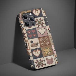 May include: A patterned phone case featuring a patchwork design with hearts, stars, and floral motifs in shades of beige, blue, and red. The case has a textured appearance and a protective design.