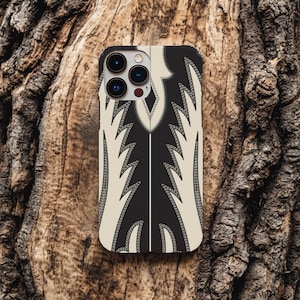 May include: A phone case featuring a black and cream-colored design reminiscent of a cowboy boot. The case has a central black panel with cream-colored accents and decorative stitching. The phone's camera lenses are visible at the top.