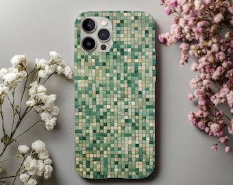 May include: A mobile phone case featuring a mosaic tile pattern in green and beige hues. The case has a curved design and a camera aperture. White and pink flowers are arranged around the phone case on a grey backdrop.