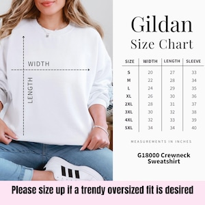 May include: A white Gildan crewneck sweatshirt with a size chart. The chart shows measurements in inches for sizes S to 5XL, including width, length, and sleeve length. The text "Please size up if a trendy oversized fit is desired" is at the bottom.