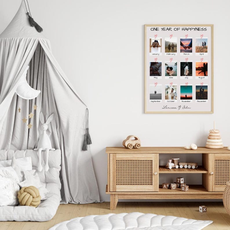 May include: A white framed print with a collage of 12 photos, each representing a month of the year. The photos are arranged in a grid pattern and feature a couple in various settings. The print is titled "One Year of Happiness" and is signed "Lauren & John".