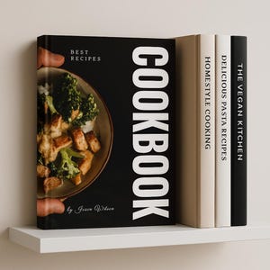 Op de afbeelding: Een stapel kookboeken op een witte plank. Het voorste boek is zwart met het woord "COOKBOOK" in grote witte letters. De omslag toont een gerecht met broccoli en kip. Andere boeken zijn "Homestyle Cooking", "Delicious Pasta Recipes" en "The Vegan Kitchen".