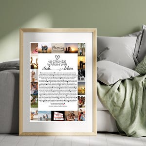 May include: A framed print with a light wood frame. The print features a collage of family photos and text in German that reads "40 Gr&uuml;nde warum wir dish leben." The print is displayed on a bed with pillows and a green blanket.