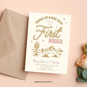 May include: An invitation card with a rodeo theme. The card features the text "Saddle Up & Ride Over, It's Our Girl, First Rodeo" in a decorative font. The design includes a desert landscape with cacti and mountains. An envelope is visible.