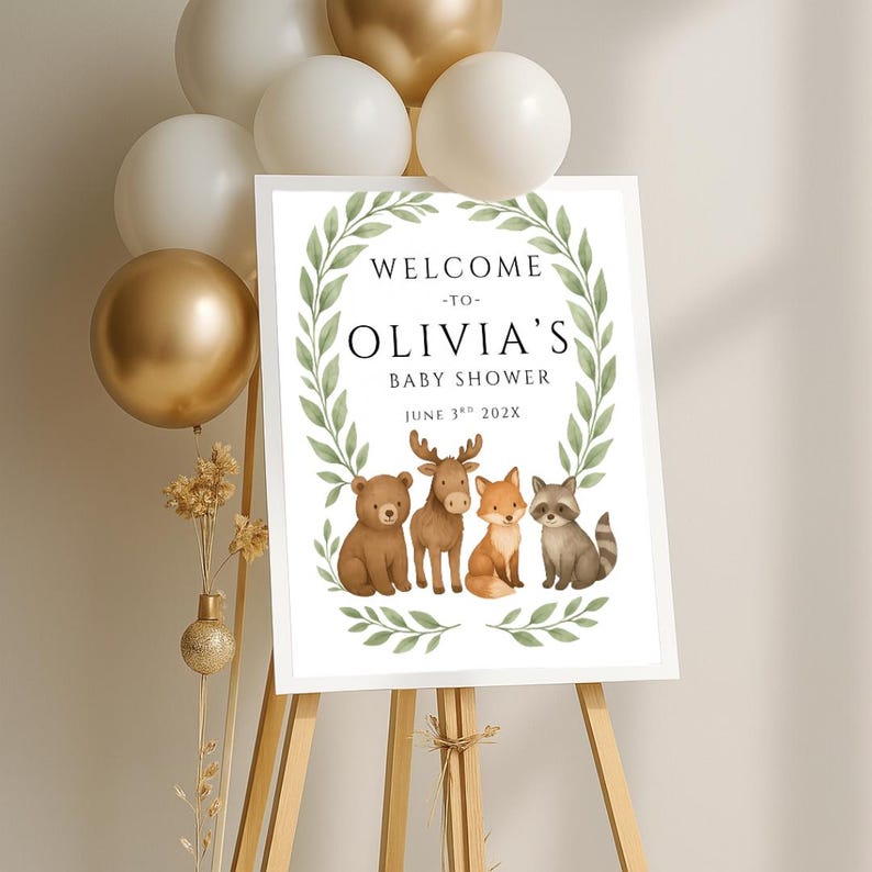 May include: Welcome to Olivia's Baby Shower sign with a green leafy wreath and woodland animals including a bear, moose, fox, and raccoon. The date is June 3rd, 202X.