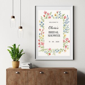 May include: A white printable bridal shower sign with a floral border. The text reads "Welcome to Olivia's Bridal Shower 13. 05. 2025".