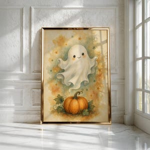 May include: A framed wall art print featuring a watercolor illustration of a smiling white ghost floating above an orange pumpkin. The background is a soft blend of yellow, orange, and green hues, decorated with small scattered stars in various colors.