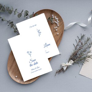 Puede incluir: Dos tarjetas blancas de guardar la fecha con ilustraciones florales azules y el texto "Save the date" y "Olivia & Liam".