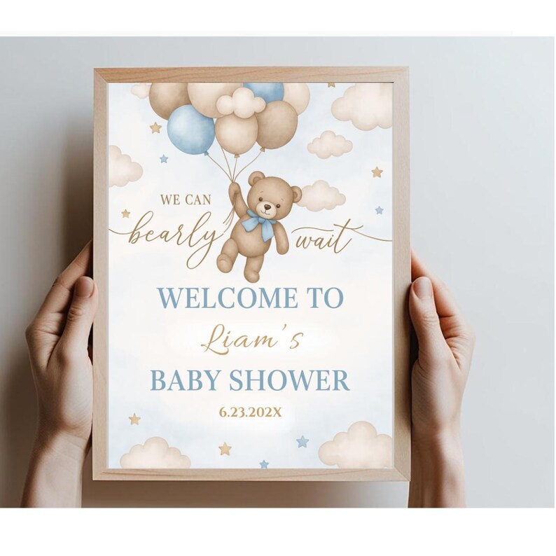 May include: A blue and brown baby shower welcome sign with a teddy bear holding balloons. The sign says "We can barely wait. Welcome to Liam's Baby Shower 6.23.202X".