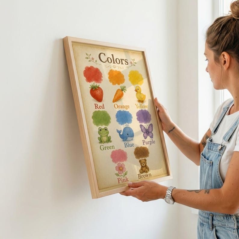 May include: A framed educational wall art print titled Colors, featuring watercolour illustrations of a red strawberry, orange carrot, yellow duck, green frog, blue whale, purple butterfly, pink flower, and brown teddy bear on a light background.