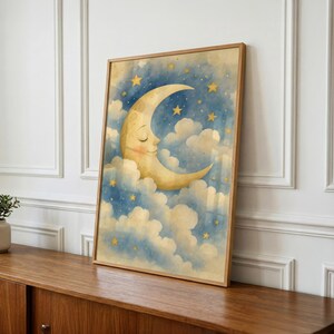 Pu&ograve; includere: Una stampa artistica da parete incorniciata raffigurante un'illustrazione ad acquerello di una luna crescente sorridente con gli occhi chiusi, immersa tra soffici nuvole bianche su un cielo notturno blu profondo pieno di stelle gialle sparse.