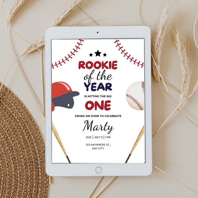 May include: A baseball-themed birthday invitation for a one-year-old boy. The invitation features a red, white, and blue baseball cap, a baseball, and two baseball bats. The text reads "Rookie of the Year is hitting the big one" and "Swing on over to celebrate Marty". The invitation also includes the date, time, and location of the party.