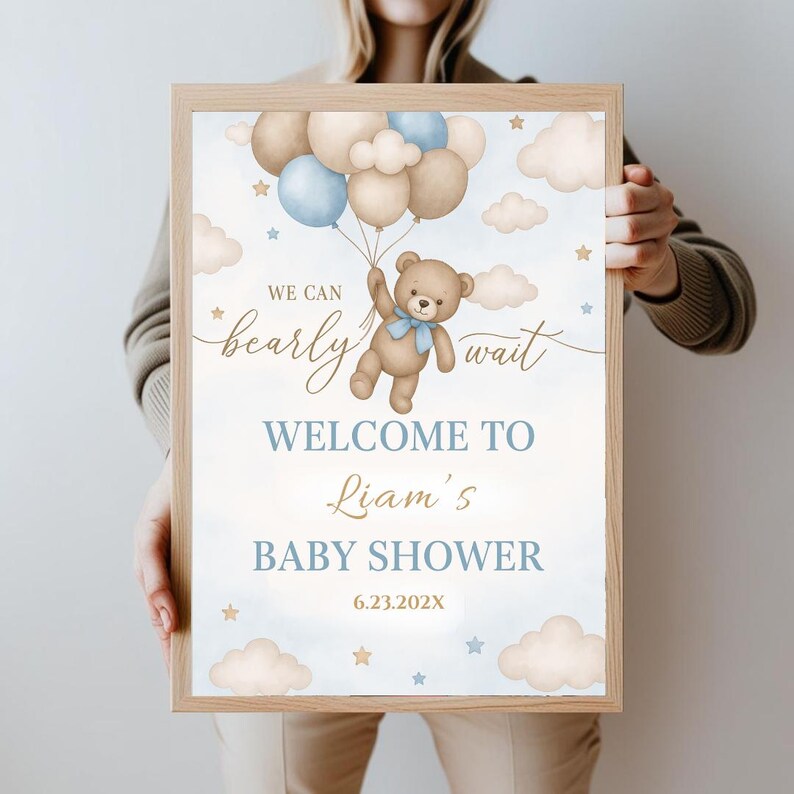 May include: A blue and brown baby shower welcome sign with a teddy bear holding balloons. The sign says "We can barely wait, Welcome to Liam's Baby Shower, 6.23.202X".