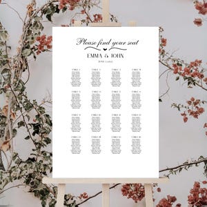 K&ouml;nnte beinhalten: Ein wei&szlig;er Hochzeitssitzplan mit dem Text "Bitte finden Sie Ihren Platz" und "Emma & John" mit dem Datum "3. Juni 2023". Der Plan listet die Tische 1 bis 16 mit den Namen der G&auml;ste auf.