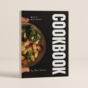 Op de afbeelding: Een zwart kookboek met het woord "COOKBOOK" in grote witte letters aan de rechterkant. De omslag toont een kom met eten en de tekst "BEST RECIPES" en "by Jason Wrison".