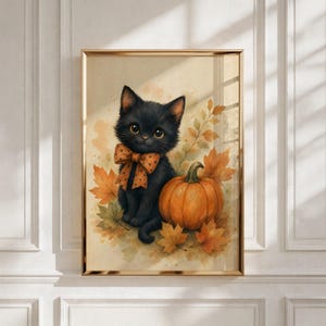 May include: A framed wall art print featuring a fluffy black kitten with large eyes wearing an orange polka-dot bow tie, sitting next to a round orange pumpkin surrounded by scattered autumn leaves in shades of yellow and brown.