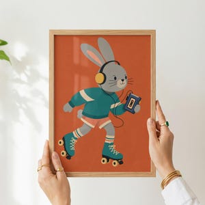 Peut inclure: Une impression d'art encadr&eacute;e repr&eacute;sentant un lapin gris portant un casque jaune et un pull bleu sarcelle, patinant sur des patins &agrave; roulettes tout en tenant un lecteur de cassette portable sur un fond orange br&ucirc;l&eacute;.