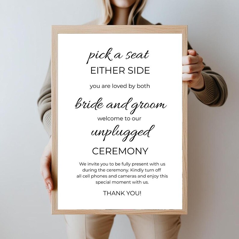 May include: A white sign with black text that reads "pick a seat either side you are loved by both bride and groom welcome to our unplugged ceremony we invite you to be fully present with us during the ceremony kindly turn off all cell phones and cameras and enjoy this special moment with us thank you!"