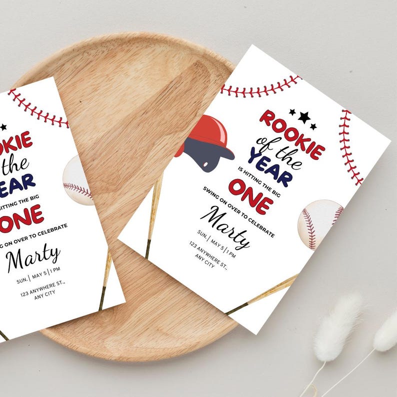 May include: Baseball-themed first birthday party invitation with red, white, and blue colors. The invitation says "Rookie of the Year is hitting the big one" and includes a baseball, bat, and baseball cap. The invitation is for Marty's first birthday party on Sunday, May 5th at 1 PM.