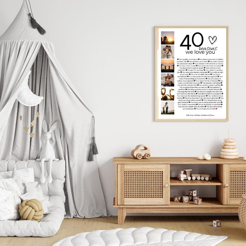 May include: A white framed print with a collage of photos and text that reads "40 reasons we love you". The text is in black and the heart is red. The print is hanging on a white wall above a wooden cabinet.