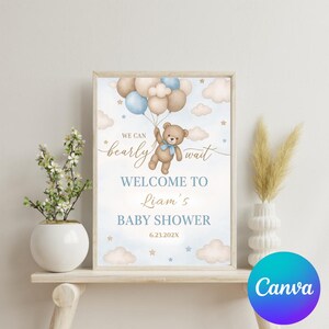 May include: A blue and brown baby shower welcome sign with a teddy bear holding balloons. The sign says "We can barely wait" and "Welcome to Liam's Baby Shower 6.23.202X".