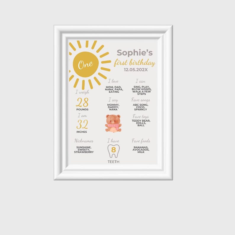 May include: A yellow sun graphic with the word "One" inside. A white frame with a light gray background contains a first birthday milestone poster for a baby named Sophie. The poster includes details like weight, height, favorite foods, and activities. The poster is decorated with a teddy bear and a tooth graphic.