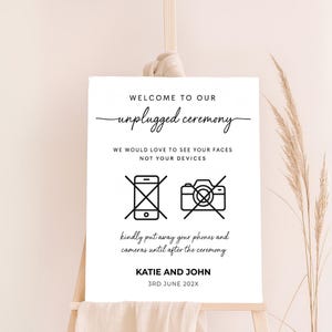 Modern unplugged wedding sign with crossed-out phone and camera icons, custom couple name and date. Clean design with script and sans-serif fonts, ideal for contemporary weddings.