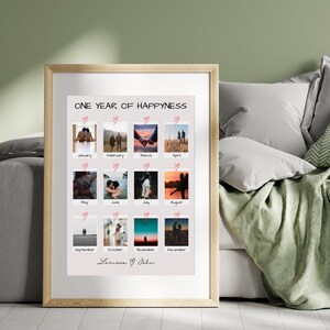 May include: A framed print with a collage of 12 photos of a couple, each photo representing a different month of the year. The title of the print is "One Year of Happiness" and the couple's names are "Lerissa & John" at the bottom.