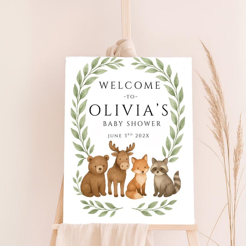 May include: Welcome to Olivia's Baby Shower sign with a green leafy wreath and four woodland animals: a bear, moose, fox, and raccoon. The date is June 3rd, 202X.