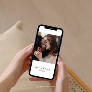 Op de afbeelding: Een smartphone toont een trouwfoto van een kussend stel. Het telefoonscherm toont de namen "Olivia en Peter" en de datum "03.06.202X" in een minimalistisch ontwerp. De telefoon wordt in de handen van een persoon gehouden.
