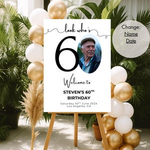 May include: A white sign with black text and a photo of a man. The sign says "look who's 60" and "Welcome to STEVEN'S 60TH BIRTHDAY". The date and location are also included: "Saturday 30th June 202X Los Angeles, CA".