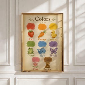 May include: A framed educational wall art print titled Colors, featuring illustrations of a red strawberry, orange carrot, yellow duck, green frog, blue whale, purple butterfly, pink flower, and brown teddy bear, each with its color name below.