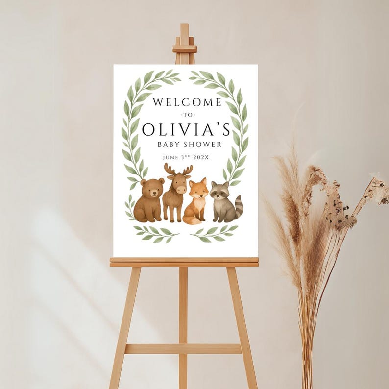 Woodland baby shower welcome sign featuring cute forest animals—a bear, moose, fox, and raccoon—framed by watercolor greenery. Customizable for any baby shower with editable name and date.